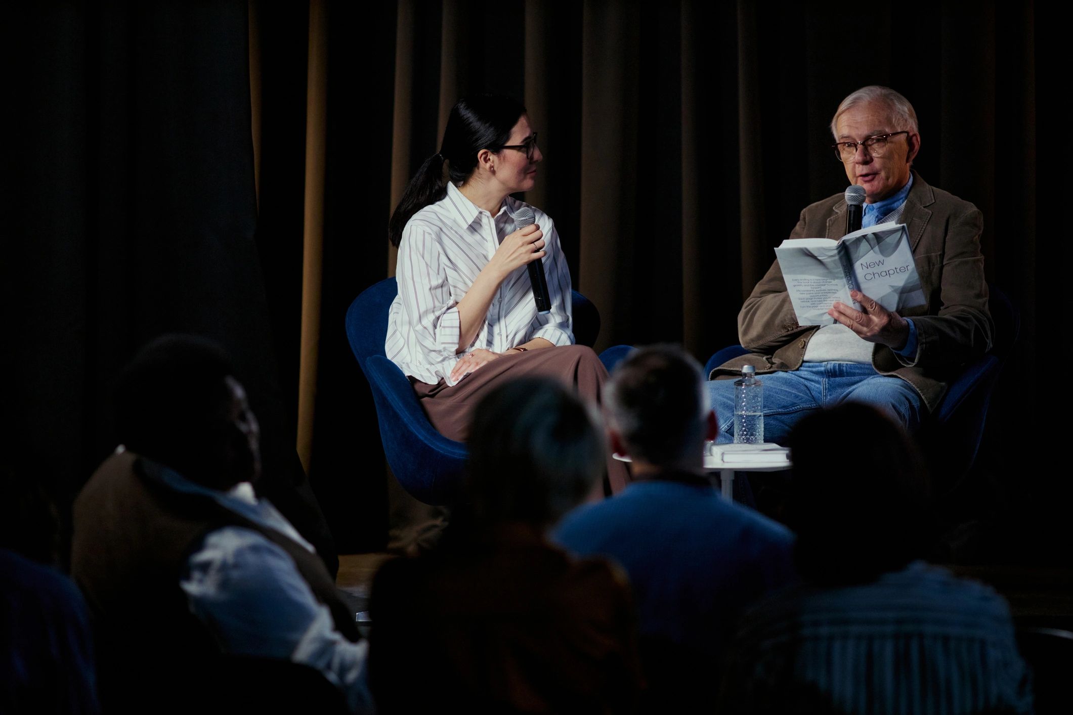Speaker reading on stage during a live audience event